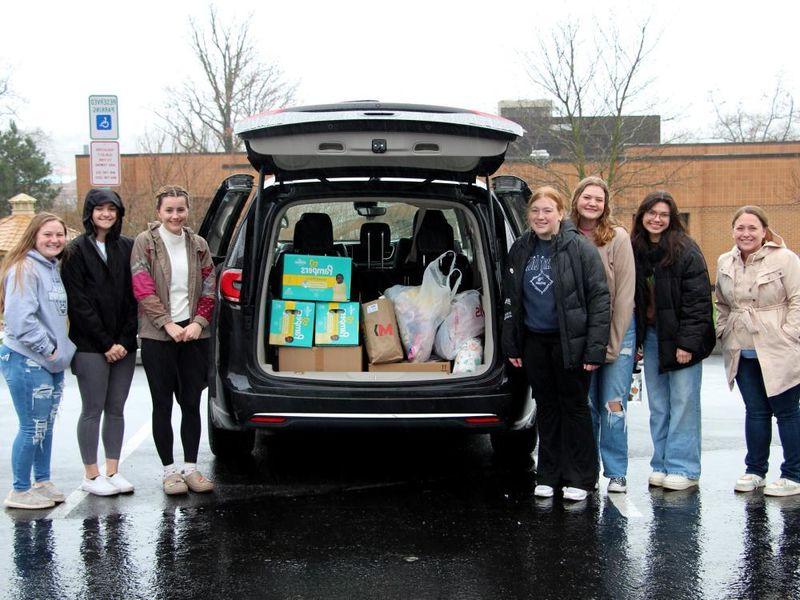 365英国上市杜波依斯分校HDFS俱乐部的成员站在装满捐赠物品的车辆旁，准备前往匹兹堡的Hello Neighbor地点.